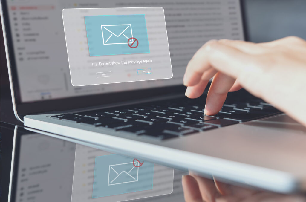 blocking spam e mail, warning pop up for phishing mail, network security concept. business woman working on laptop computer at home with warning window